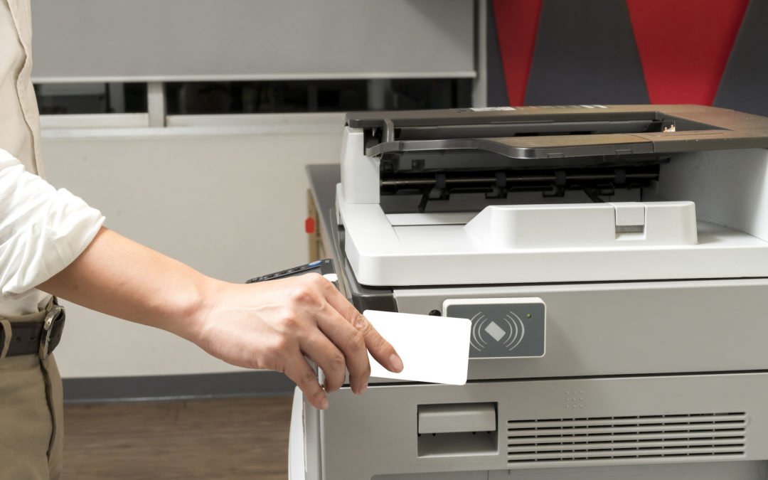 man hand hold card for scanning key card to access Photocopier . Security system concept