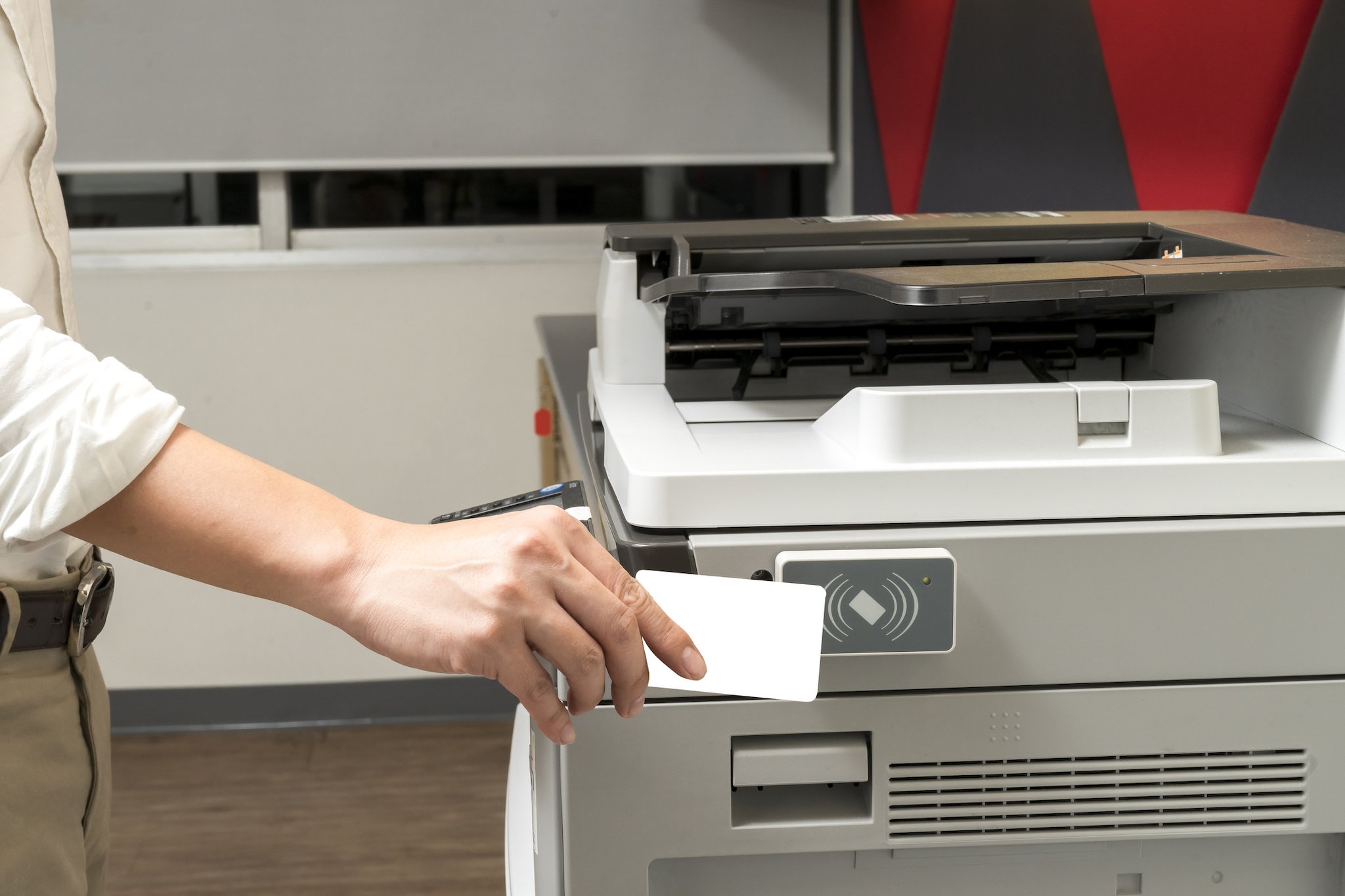man hand hold card for scanning key card to access Photocopier . Security system concept