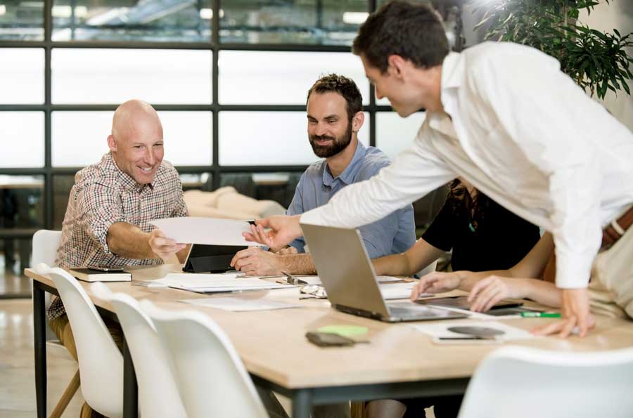 Employees in boardroom discussing projects.